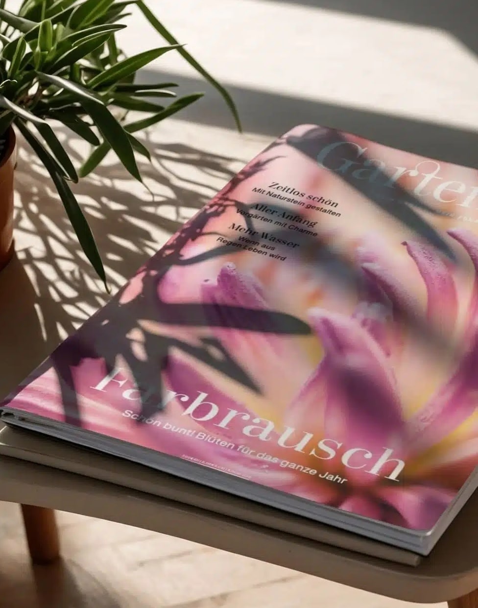 Teaserbild_GatrenArt_980x1251 Cover des GartenArt Magazins mit einer Hand und verschiedenen Pflanzenmotiven in einem illustrativen Design.